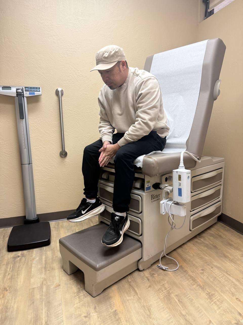 TJ Lee sitting on an exam table at his first checkup in more than 20 years, earlier in 2026